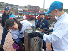Subgerente General limpiando  caneca de basura en el sector de San Cristobal