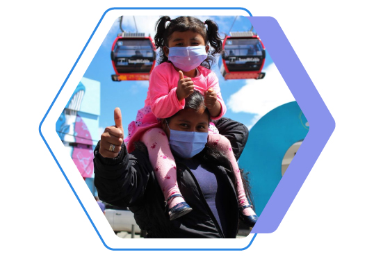 Mujer con una niña levantando el pulgar, de fondo cabinas  de TransMiCable