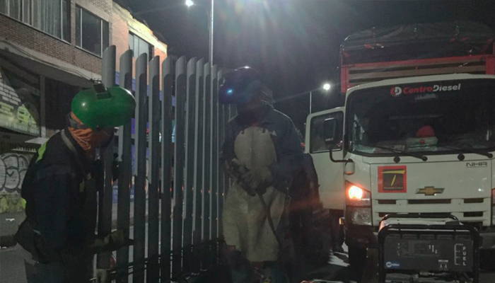 Imagen donde dos personas están soldando los cerramientos perimetrales en  una estación